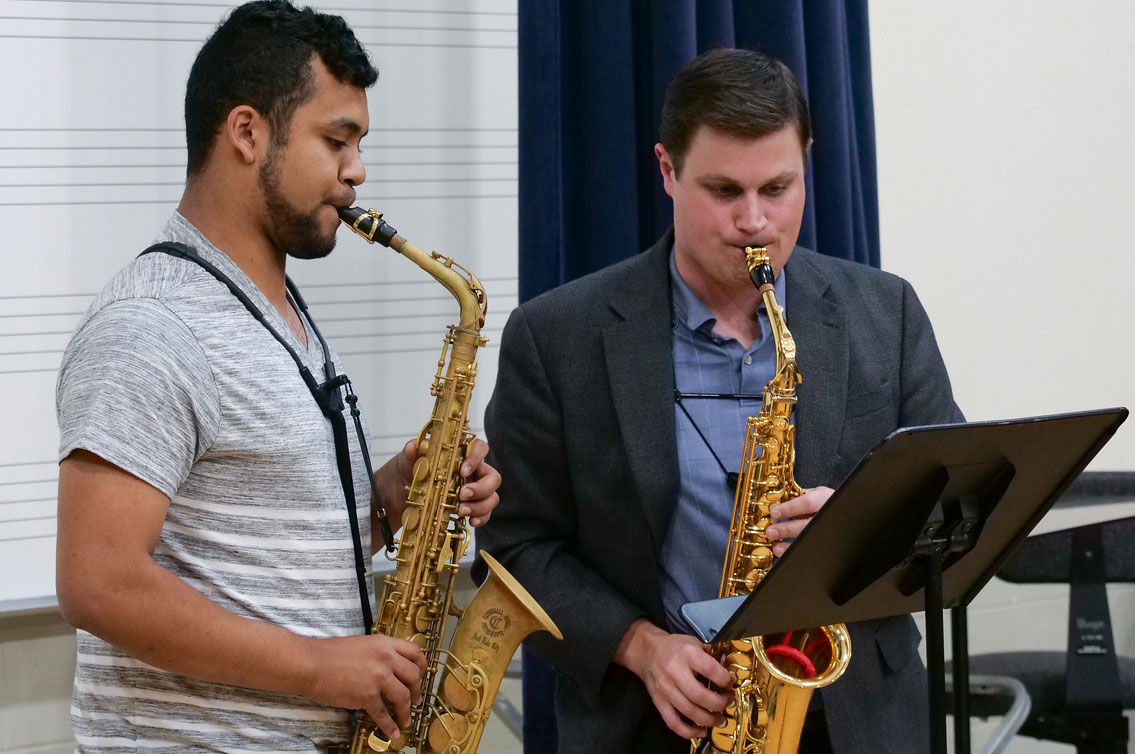 Student and Professor playing saxophone.