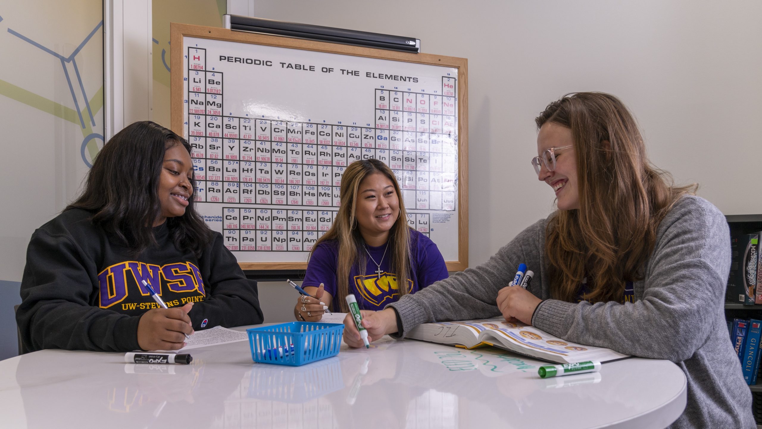 Students around a table being tutored