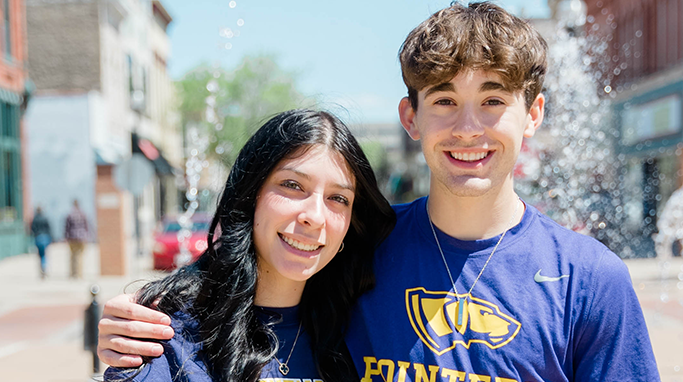 Smiling female and male student in downtown Stevens Point.